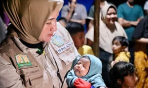 Ketua TP PKK Aceh Marlina Muzakir menyerahkan bantuan banjir Aceh Utara di posko pengungsian Kecamatan Langkahan