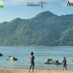 Pantai Lampuuk Aceh Besar dengan pasir putih, ombak laut, dan wisatawan menikmati aktivitas pantai