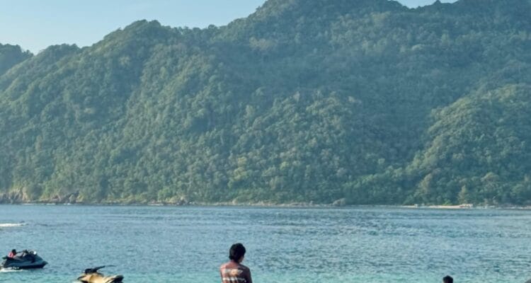 Pantai Lampuuk Aceh Besar dengan pasir putih, ombak laut, dan wisatawan menikmati aktivitas pantai